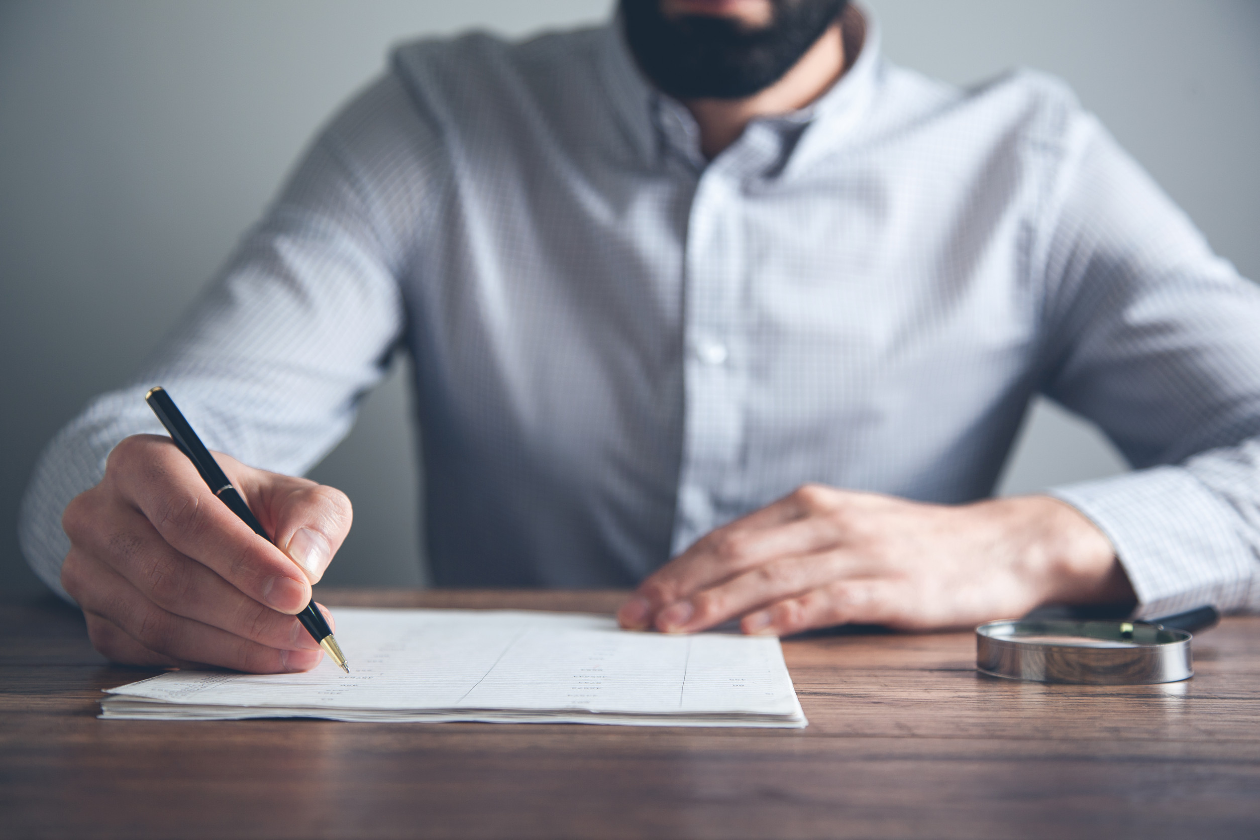 man hand document with magnifier on desk